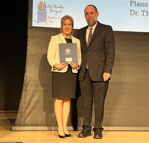 superintendent williams accepting award from plano pta council president ross cornell